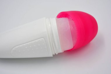 Beyaz arka planda pembe kapaklı kadın deodorantının ilginç bir plastik ambalajı bulunuyor..