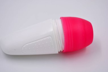 Beyaz arka planda pembe kapaklı kadın deodorantının ilginç bir plastik ambalajı bulunuyor..