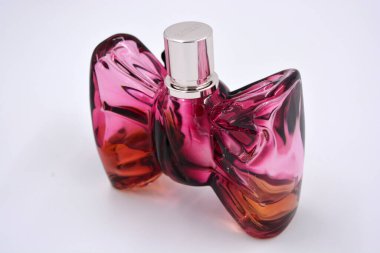 Beyaz bir arka planda kiraz aromalı güzel bir kırmızı, kirazlı, erik kokulu kadın parfümü bulunur..