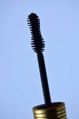 Dekoratif kozmetik ürünleri, kişisel bakım ürünleri, altın kaplamalı kadın siyah rimelleri, beyaz bir arka planda yer alıyor..