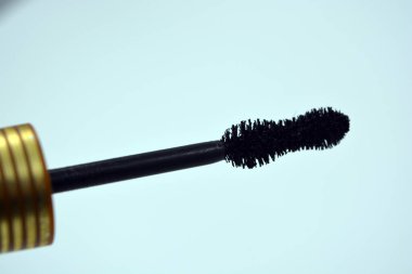 Dekoratif kozmetik ürünleri, kişisel bakım ürünleri, altın kaplamalı kadın siyah rimelleri, beyaz bir arka planda yer alıyor..