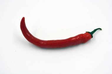 Taze sebzeler, baharatlı baharatlar, parlak kırmızı ince ve çok sıcak kırmızı biberler beyaz arka planda yer alır..