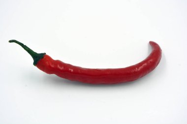 Taze sebzeler, baharatlı baharatlar, parlak kırmızı ince ve çok sıcak kırmızı biberler beyaz arka planda yer alır..