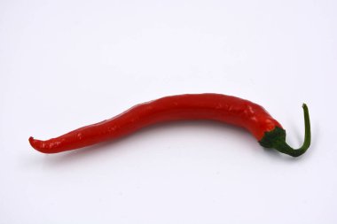 Taze sebzeler, baharatlı baharatlar, parlak kırmızı ince ve çok sıcak kırmızı biberler beyaz arka planda yer alır..