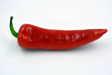 Parlak taze sebzeler, tatlı kırmızı biber, parlak kırmızı büyük biber beyaz arka planda yer alır.. 