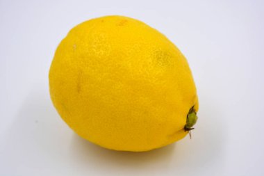 Lezzetli ve sağlıklı olgun meyveler, beyaz arka planda büyük sarı bir limon..