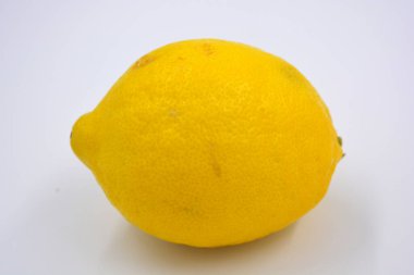 Lezzetli ve sağlıklı olgun meyveler, beyaz arka planda büyük sarı bir limon..