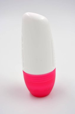 Beyaz arka planda pembe kapaklı kadın deodorantının ilginç bir plastik ambalajı bulunuyor..