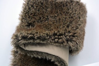 Doğal tarçın sarısı kürklü yumuşak sentetik kumaş. Beyaz arka planda kumaş astarlı..