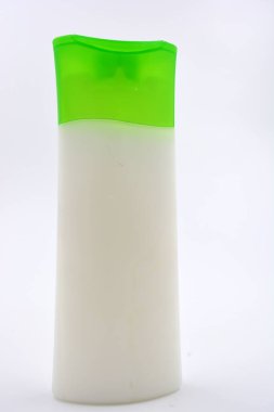 Kozmetik ürünleri, yüz kremi, yüz ve vücut bakımı şeffaf plastik bir şişede yeşil kapaklı beyaz arka planda yer almaktadır..