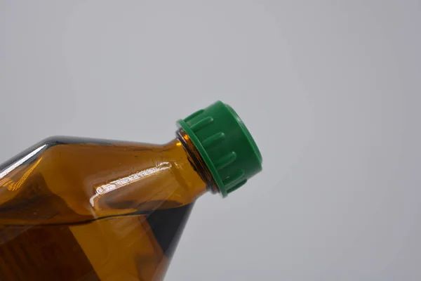 A medical small bottle of medicine with a liquid made of black, brown glass and located on a white background.