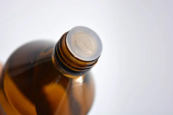 A medical small bottle of medicine with a liquid made of black, brown glass and located on a white background.