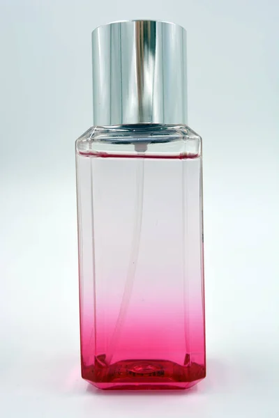 明るく美しい透明 トイレスプレーのピンクのボトル 白い背景に位置する高価な女性の香水 — ストック写真