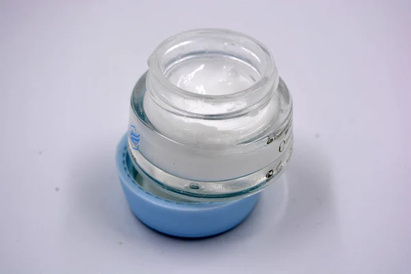 心地よい香りの白い顔のクリーム 厚いガラス瓶の顔のスキンケア 青い蓋のある瓶 白い背景に位置しています — ストック写真