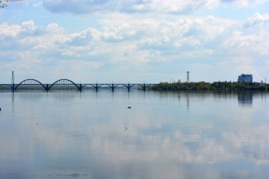 Dnipropetrovsk (Dnipro) şehrinin güzel, ilgi çekici arka planı, gökdelenleri, evleri, köprüleri, Dnipro Nehri üzerinde duran yeşil ağaçlar, Ukrayna ülkesi.