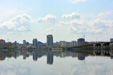 Dnipropetrovsk (Dnipro) şehrinin güzel, ilgi çekici arka planı, gökdelenleri, evleri, köprüleri, Dnipro Nehri üzerinde duran yeşil ağaçlar, Ukrayna ülkesi.