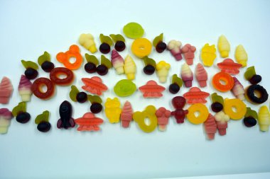 Parlak, sulu ve sıradışı jöle, jelibonlar, beyaz bir arka planda değişik şekil ve boyutlarda şekerler. Ukrayna 'daki fabrikalar tarafından yapılan Ukrayna tatlıları.