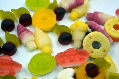 Parlak, sulu ve sıradışı jöle, jelibonlar, beyaz bir arka planda değişik şekil ve boyutlarda şekerler. Ukrayna 'daki fabrikalar tarafından yapılan Ukrayna tatlıları.