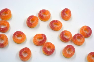 Beautiful and bright colored sweets in the form of orange and red doughnuts in sugar powder. 
