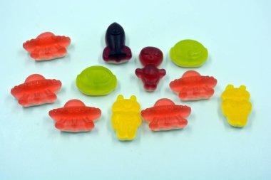 Uzaylılar, astronotlar, UFO 'lar, uzay gemileri, beyaz bir arka planda yer alan uzay roketleri şeklinde güzel ve parlak renkli şekerler.. 