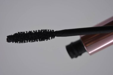 Kadın kozmetiği, güzel pembe metal göz fırçası, beyaz arka planda siyah stil rimel seti..