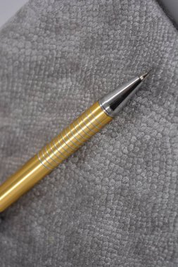 Çok şık, lüks, kadife, gri defter, iş günlüğü, beyaz plastik arka planda altın renkli kalemle düzenlenmiş kitap..