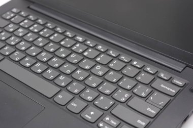 Basit, minyatür, hesap makinesi tuşları olmayan ince bir klavyesi olan güzel, siyah bir laptop..