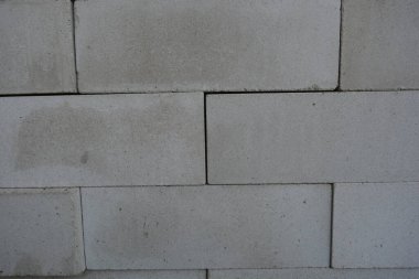 İnşaat malzemeleri, yeni beyaz tuğlalar yoğun ve güzel döşenmiş. Binanın arka planı, beton, beyaz tuğlalar.