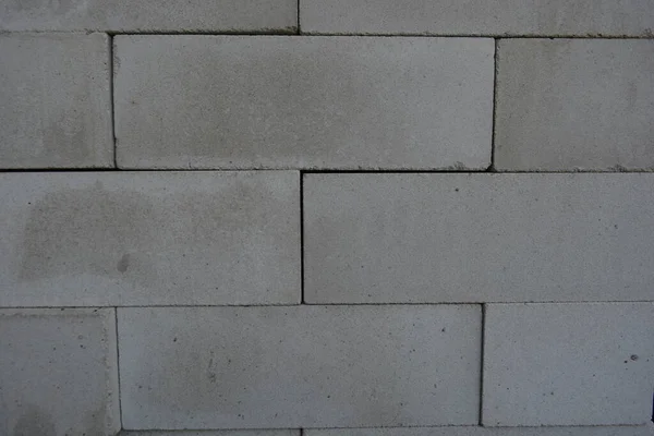 Building materials, new white bricks laid out densely and beautifully. Background of building, cement, white bricks.