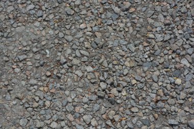Gri küçük çakıl taşlarıyla kaplı bir inşaat yolu..