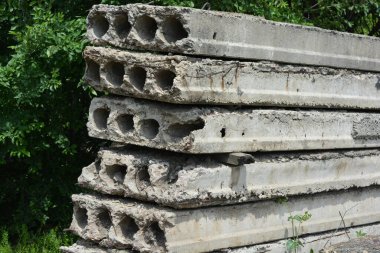 Eski gri yapı malzemeleri, bir sürü metal çimento, doğada ağaçların olduğu yere beton yapı taşları..