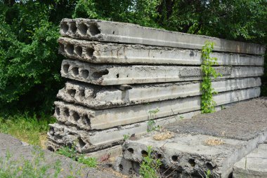 Eski gri yapı malzemeleri, bir sürü metal çimento, doğada ağaçların olduğu yere beton yapı taşları..