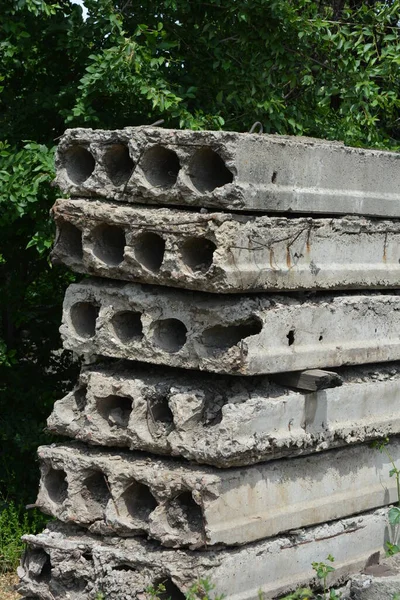 Eski gri yapı malzemeleri, bir sürü metal çimento, doğada ağaçların olduğu yere beton yapı taşları..