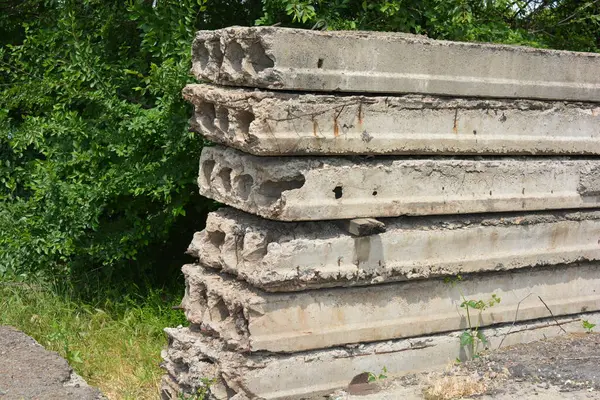 Eski gri yapı malzemeleri, bir sürü metal çimento, doğada ağaçların olduğu yere beton yapı taşları..