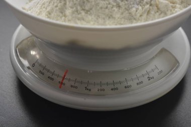 Ev yapımı, masa üstü, buğday unlu beyaz ağırlıklar mutfağın gri tezgahında bulunur..