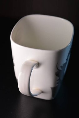 İki tarafı gri desenli güzel, beyaz kare porselen bir bardak..