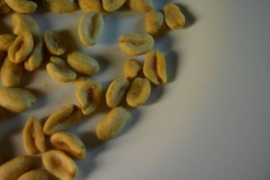 Sağlıklı yiyecekler, sağlıklı yiyecekler, fındıklar, tuzlu fıstıklar ilginç bir şekilde beyaz cam bir tabakta dizilmiştir..