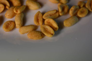 Sağlıklı yiyecekler, sağlıklı yiyecekler, fındıklar, tuzlu fıstıklar ilginç bir şekilde beyaz cam bir tabakta dizilmiştir..