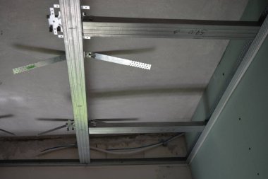 İnşaat malzemeleri, odaların yenilenmesi, metal yapılar, evin duvarlarına ve tavanına metal profil ve alçı döşeme süreci.