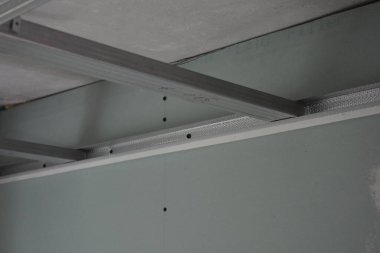 İnşaat malzemeleri, odaların yenilenmesi, metal yapılar, evin duvarlarına ve tavanına metal profil ve alçı döşeme süreci.