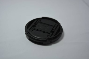 DSLR kamerasının yuvarlak siyah kapağı beyaz arka planda yer almaktadır.