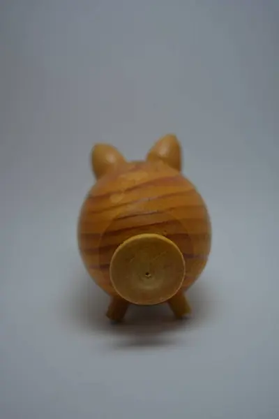 Ukrainian hodgepodge made of natural wood in the form of a pig and placed on a white background.