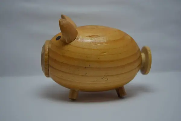 Ukrainian hodgepodge made of natural wood in the form of a pig and placed on a white background.