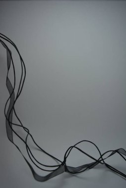 Güzel küçük siyah uzun ipler, şeffaf siyah kurdele beyaz arka planda güzelce yerleştirilmiş..