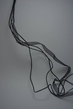 Güzel küçük siyah uzun ipler, şeffaf siyah kurdele beyaz arka planda güzelce yerleştirilmiş..