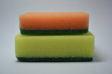 Evde sıkça kullanılan şeyler. Bulaşık yıkamak için renkli havlular beyaz arka planda düzenlenir..