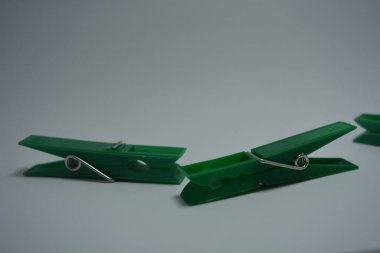 Günlük hayatta kullanılan olağan şeyler bunlar. Beyaz arkaplana yerleştirilmiş güzel yeşil plastik mandallar.