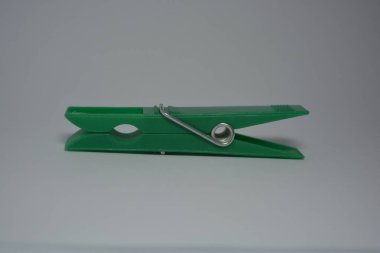 Günlük hayatta kullanılan olağan şeyler bunlar. Beyaz arkaplana yerleştirilmiş güzel yeşil plastik mandallar.