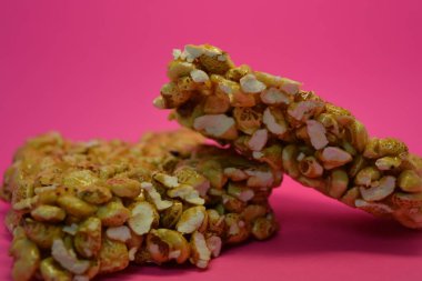 Kahvaltı, alışılmadık şekerler, bir kalıp fındık, karamelli pirinç pembe arka planda yer alır..