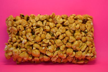 Kahvaltı, alışılmadık şekerler, bir kalıp fındık, karamelli pirinç pembe arka planda yer alır..